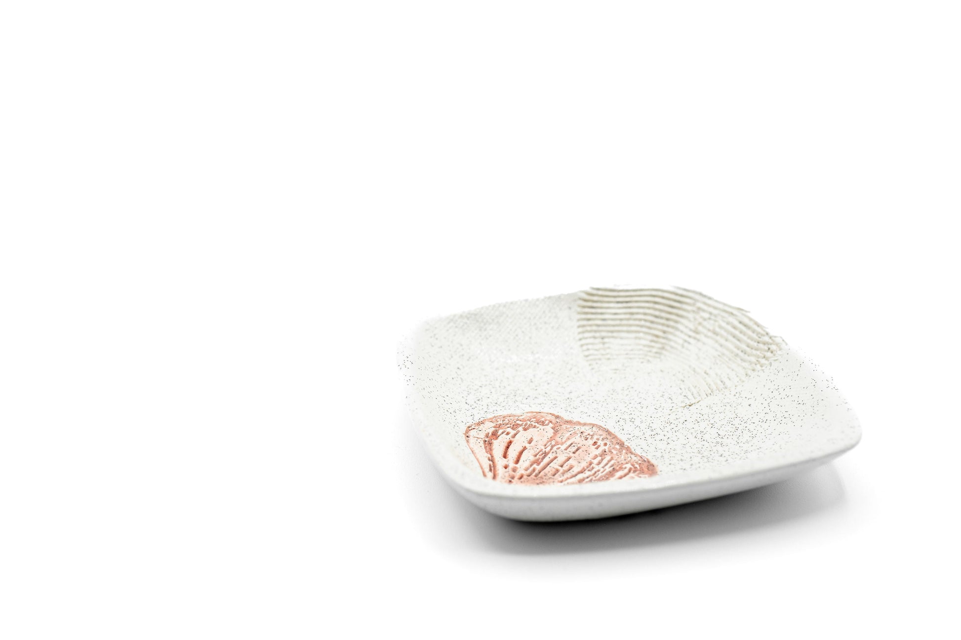 Awhite ceramic dipping plate with a garlic print design